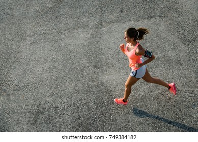 Top View Of Sporty Young Fit Woman Running On Urban Asphalt. Female Athlete Training Outside In Summer.