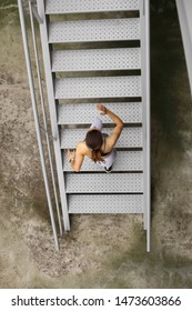 Top View Of Sporty Young Woman On Fitness And Running Urban Workout Climbing Stairs For Hiit Cardio Training.