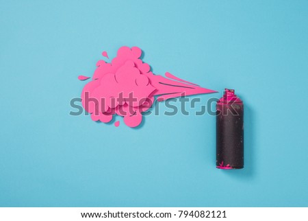 top view of spray paint in can and paper splashes isolated on blue