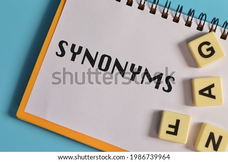 Top view of square letters and notebook written with SYNONYMS