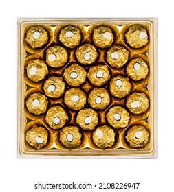 Top View Of Square Shaped Sweet Dessert Box With Many Round Chocolate Candy In Gold Wrapping Packaging Isolated On White Background