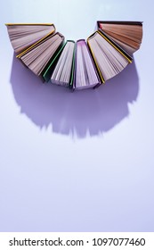 Top View Of Stack Of Books In Half Circle On Violet Table