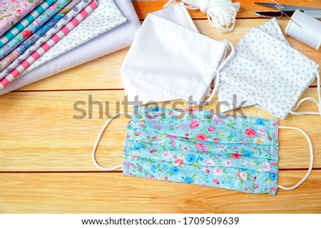 Top view of Stack cotton and DIY fabric face mask on wood table. Protect saliva, cough, dust, pollution (PM2.5), virus, bacteria, Covid-19 (Coronavirus, ncov). Handmade, Healthy concept. Copy space.
