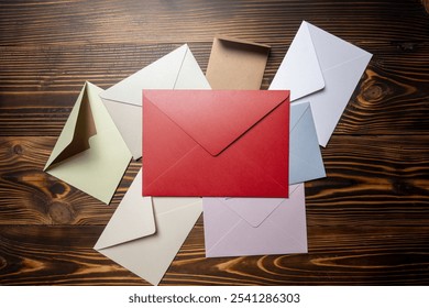 Top view of stack of envelope and postcard on wooden background. envelopes are of different variation size and colors. Mockup, blank template, copy space. Greeting or invitation card flat lay style