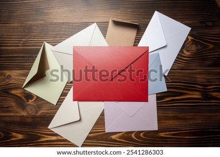 Top view of stack of envelope and postcard on wooden background. envelopes are of different variation size and colors. Mockup, blank template, copy space. Greeting or invitation card flat lay style