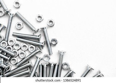 Top view of stainless steel bolts or iron nails on brigth white background with silver color.  Metal screws for use in sheet metal. - Shutterstock ID 1386524891
