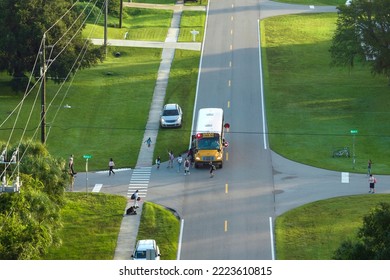 Top view of standard american yellow school bus picking up kids at rural town street stop for their lessongs in early morning. Public transport in the USA - Powered by Shutterstock