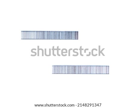 Top view of staples for a mechanical construction stapler lying on a white background.
