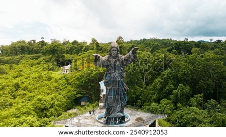 Top view Statue of Jesus on the tourist island of Sagawin Salawati Raja Ampat. Christ the King, a statue of Jesus. Travel concept. monument and aerial of Christ the Redeemer on hill for tourism. 
