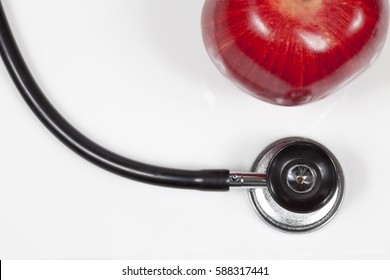 Top view of a stethoscope and apple.