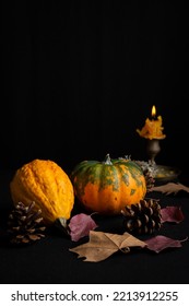 Top View Of Still Life With Pumpkins, Autumn Leaves And Lit Candle, Selective Focus, On Tablecloth And Black Background, Vertical, With Copy Space