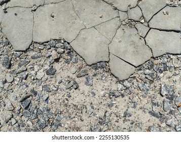 Top view of stones and old gray cracked concrete. - Shutterstock ID 2255130535
