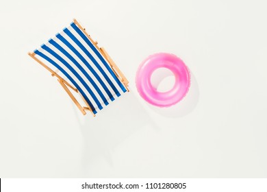 Top View Of Striped Beach Chair And Inflatable Ring Isolated On White