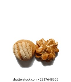 Top view studio shot of two distinct sweet baked bread rolls concha and flower shaped traditional Guatemalan bakery food isolated on clean white background