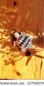 Top View Stunning Handmade Bespoke Off White  Cotton Yarn Turtle  Key Chain Lie On Wood.