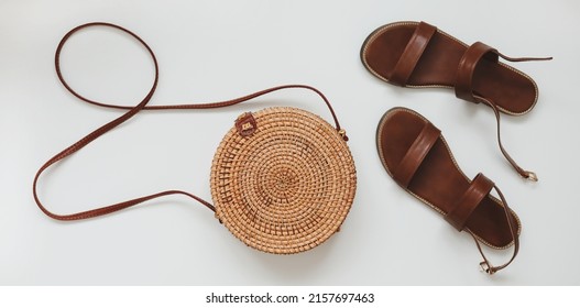  Top view of stylish female sandals and a wicker rattan bag isolated on white background. summer vacation concept