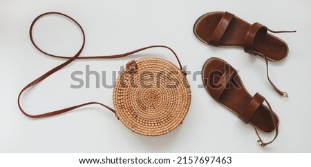  Top view of stylish female sandals and a wicker rattan bag isolated on white background. summer vacation concept