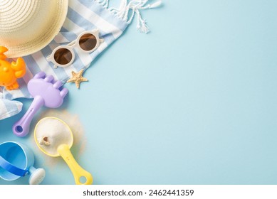 Top view of summer beach accessories laid out on a striped towel including a sun hat, sunglasses, sand toys, and a starfish - Powered by Shutterstock