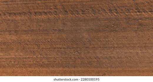 top view of surface of gravel road made of small stones and sand with traces of car tires