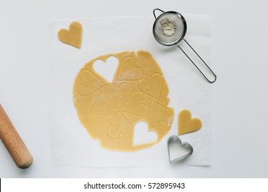 Top View Of Sweet Dough With Heart Shaped Cookie Cuttings On White Table