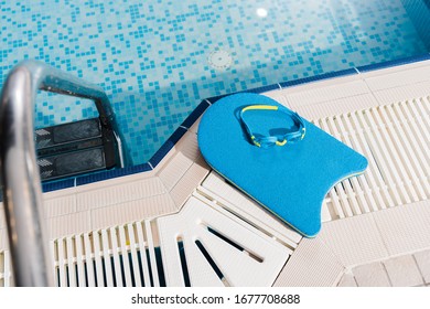 Top View Of Swim Goggles On Flutter Board Near Swimming Pool
