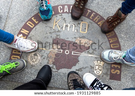 Top view of a symbol called Zero kilometre from Spain, with nine feet around. Place marked on the floor that is a sketch of the design of Spain, something symbolic.Popular meeting place Puerta del Sol