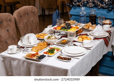 Top view of table with assorted dishes fruits and drinks in luxurious interior.