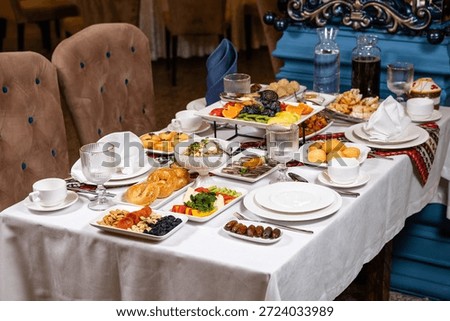Top view of table with assorted dishes fruits and drinks in luxurious interior.