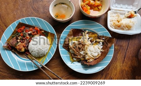 Top view of a table full of authentic traditional khmer food for breakfast of Trei boeng kanh chhet or spicy fried fish and Bai sach chrouk or pork with steamed rice