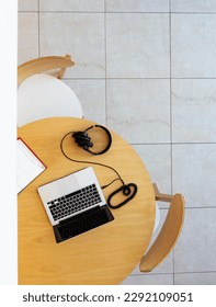 Top view of a table with notebook, laptop and headphones