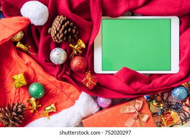 Top View Of Tablet With Green Screen And Christmas Decoration On The Table.