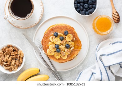 Top view of Tasty Breakfast Pancakes with honey and blueberries. Pancakes Breakfast. Banana Pancakes. Breakfast table with pancakes