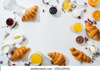 top view of tasty croissants near bowls with jam and drinks on white  - Shutterstock ID 1392129545
