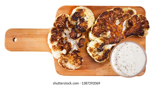 Top View Of Tasty Grilled Cauliflower Steak With White Sauce Served On Wooden Board. Vegetarian Food. Isolated Over White Background