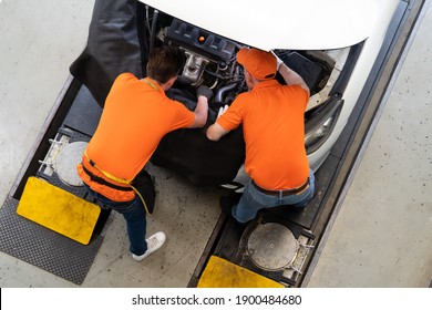 Top View Of Team Mechanic Worker Working At The Garage. Group Of Professional Mechanic Examining, Repair And Maintenance Under Hood Of Car At Auto Car Repair Service. Car Service Concept