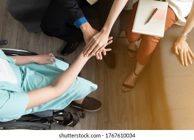 Top view of  team work join hand together, disabled woman work with her colleague at workplace
