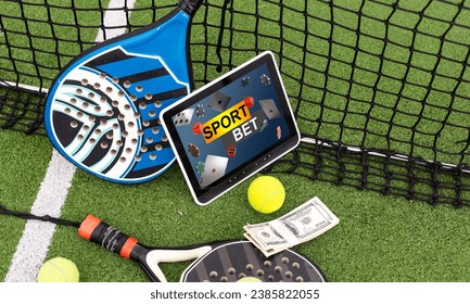 top view of tennis racket and ball near digital tablet with blank screen on green grass, sports betting concept - Powered by Shutterstock