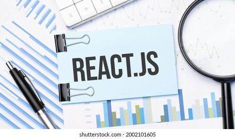 Top View Of Text React Js With Calculator, Magnifying Glass And Pen On Financial Charts . Business, Calculation, Strategy, Searching And Tax Concept. Top View.