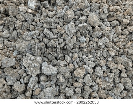 Top view texture of dark volcanic rock fragments and raw porous lava stones