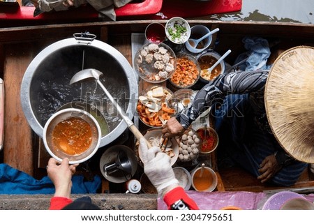 top view thai asian old woman  Making noodles on the boat  in the local floating market in the central Thai tradition  very famous  causing many tourists to come and see each other