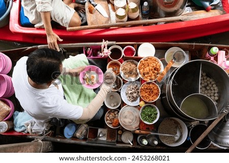 top view thai asian old woman  Making noodles on the boat  in the local floating market in the central Thai tradition  very famous  causing many tourists to come and see each other