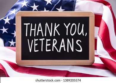 Top View Of Thank You Veterans Text Written On Slate Over American Flag - Shutterstock ID 1389205574