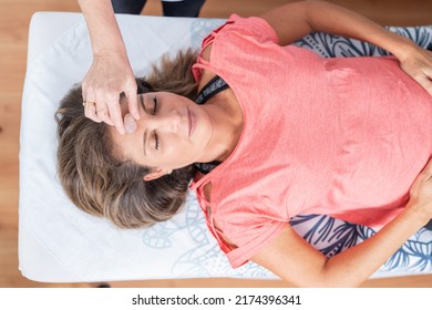 Top view of a therapist using a stone for a reiki and aromatherapy session for a patient