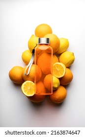 Top View Thermos Water Bottle. Orange Water Bottle On White Background With Lemons And Oranges.