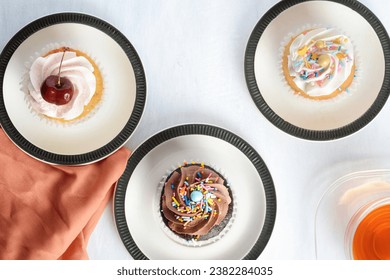 top view three cupcakes with cup of tea - Powered by Shutterstock