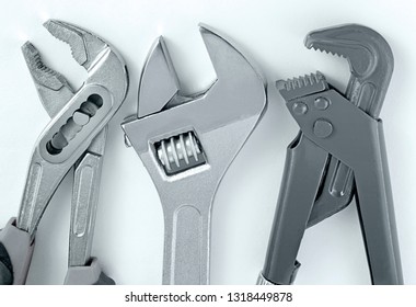 Top view of three different metal spanner wrenches and for works for gas pipes and plumbing works close up, on white background. - Shutterstock ID 1318449878