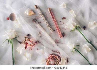 Top view of three flasks with bathroom salt with rose petals and flowers around