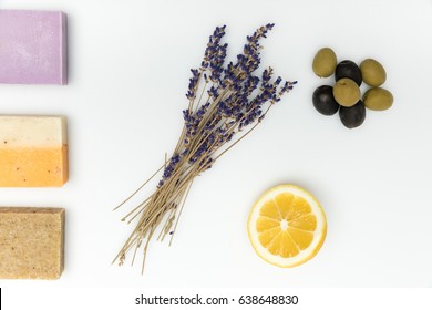 Top View Of Three Types On Homemade Soap With Dried Lavender, Olives And Lemon Isolated On White