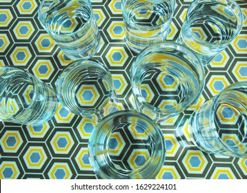 Top View Through Water Inside Several Clear Glasses Creating Distorted Image Of Colourful Octagonal Pattern Of Plastic Plate And Infinity Effect Of Circular Shapes. Visual Perception And Refraction. 