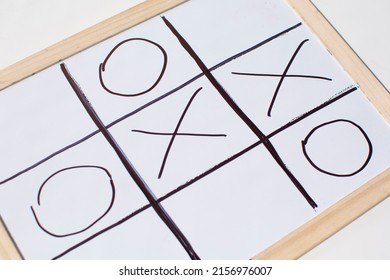 top view of tic tac toe game on blackboard , naughts and crosses - Powered by Shutterstock